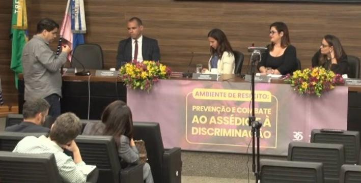 Foto mostra o coordenador do DAI, Ricardo Soares, fazendo uma pergunta aos painelistas do seminário sobre prevenção e combate ao assédio e à discriminação